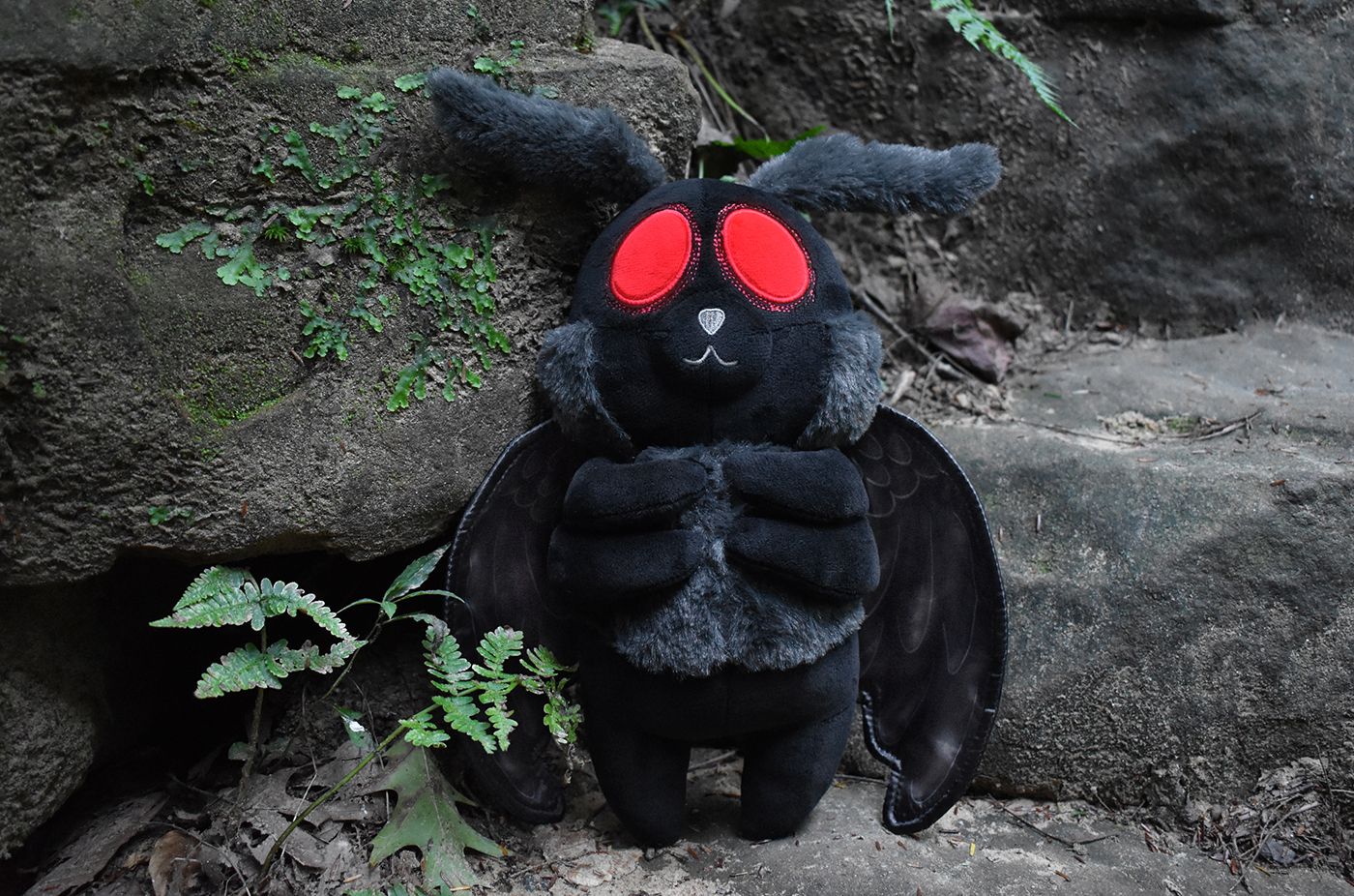 A black plush bunny doll with red eyes